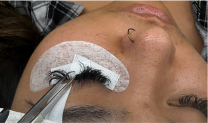Lash artist carefully applying an individual eyelash extension