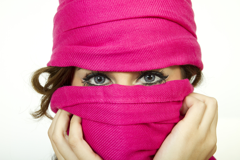 Young Woman With Beautiful Eyes Wearing Scarf. A young woman wears a warm pink scarf, accentuating her beautiful blue eyes in the cold winter weather.